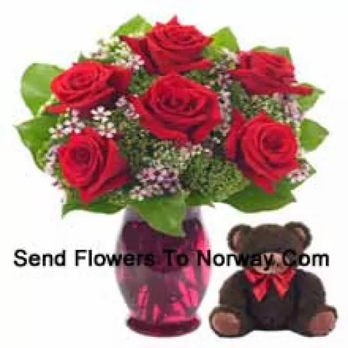 7 rote Rosen mit einigen Farnen in einer Glasvase zusammen mit einem niedlichen 14 Zoll großen Teddybär